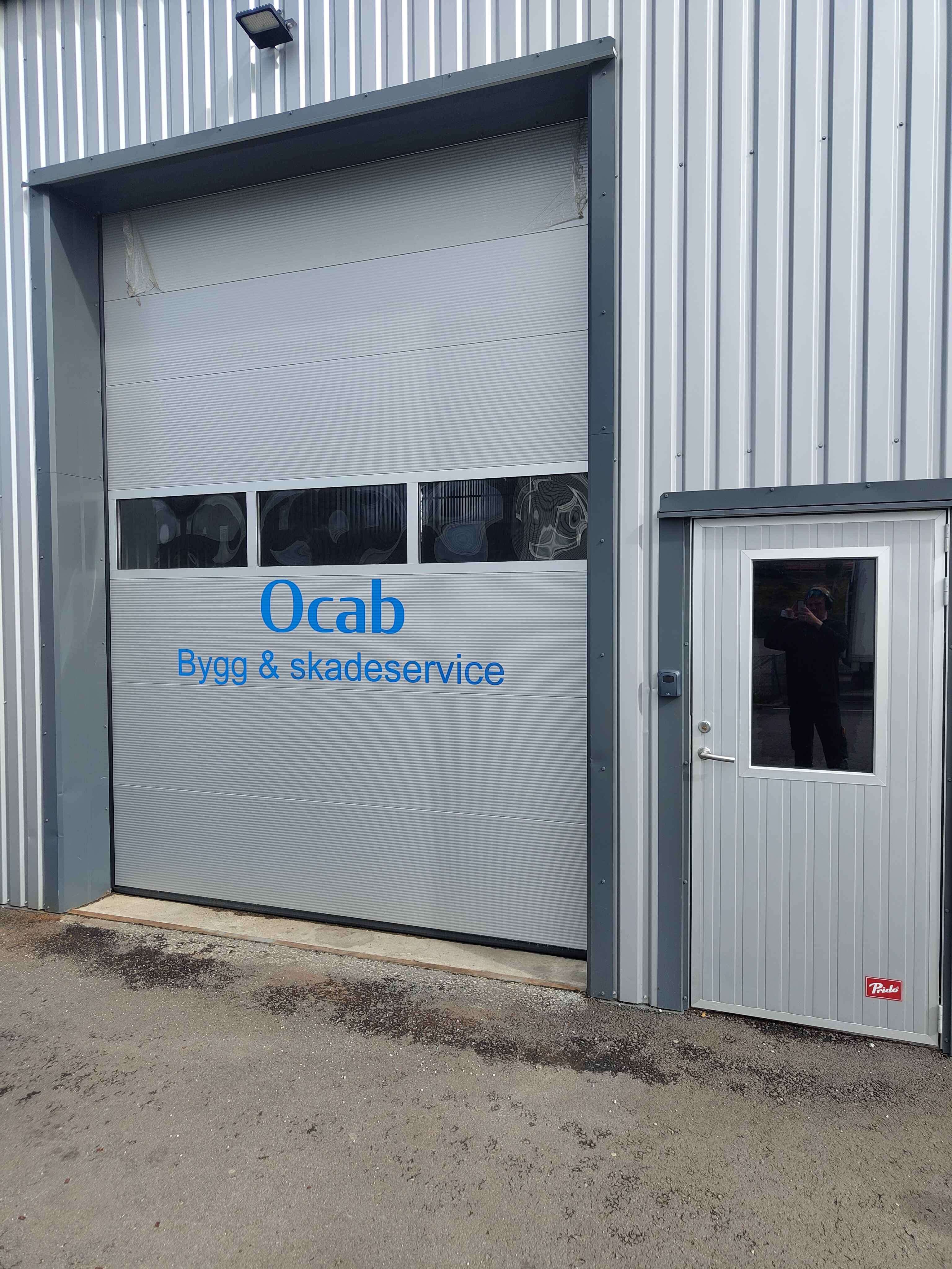 Nærbilde av port med logo for Ocab Bygg & skadeservice